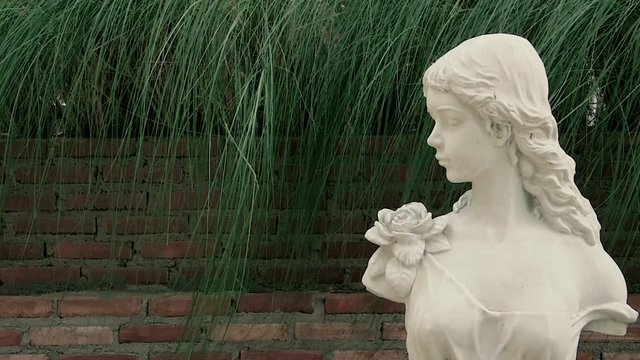 Close up white marble  holy mary statue with brick wall background. Christian religion concept with 4K resolution.