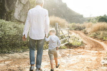 Grandfather and grandson walking at the farm - obrazy, fototapety, plakaty