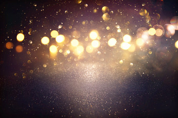 glitter vintage lights background. black and gold. de-focused.