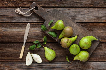 Fresh ripe pears on the vintage wooden board. Top view, close-up on vintage wooden background, space for text.