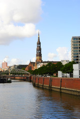 Fototapeta na wymiar Mainchurch St. Cathrine in Hamburg in Germany near a canal in the famous Speicherstadt