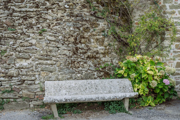 Ancient stone bench in a small village of medieval origin. Volpaia, Tuscany, Italy