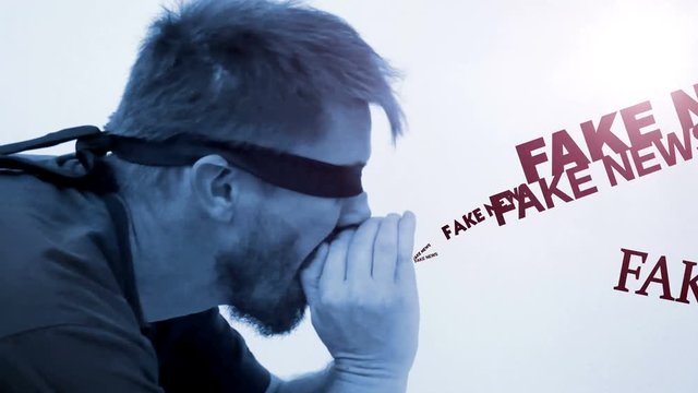 man blindfolded without knowing, screams fake news