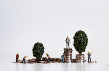 A concept of labor and income. The pile of coins and miniature people.