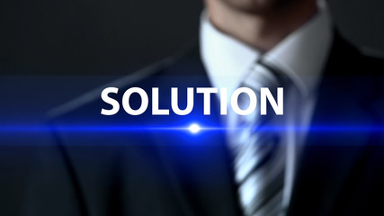 Solution, male wearing business suit standing in front of screen, key to problem
