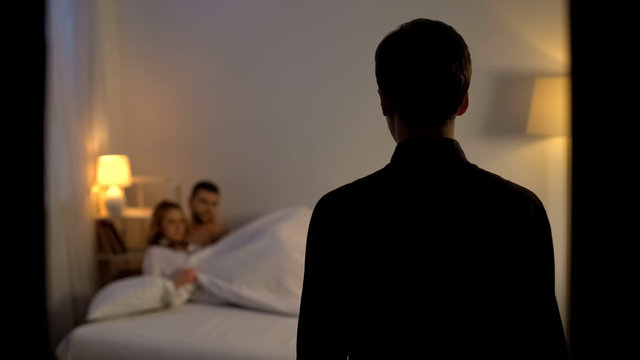 Man looking at his wife with lover in bed, unfair relations, partner cheating