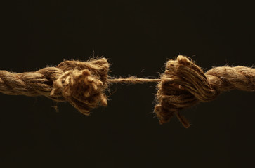 closeup.old frayed rope .isolated on a black background. - obrazy, fototapety, plakaty