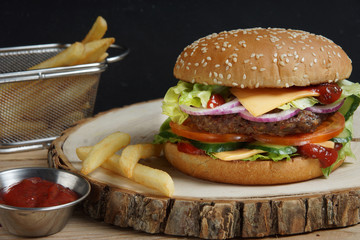 A savory large burger with a meatball, tomatoes, cucumbers, cheese, onions and salad.