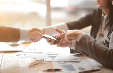 close up.a businessman uses a smartphone during a business meeting.