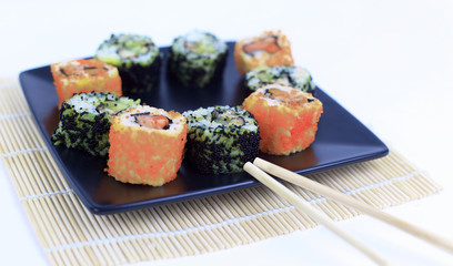 Sushi Set - different types of Maki sushi and chopsticks on a b