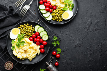Mashed potato with green peas, tomatoes and boiled egg. Potato puree on plate with vegetables and egg