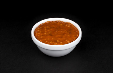 Sweet Bavarian mustard in white bowl on black background