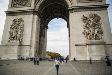 Obraz premium Girl is standing neat the arch of triumphal