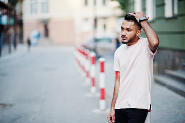 Stylish indian beard man at pink t-shirt. India model posed outdoor at streets of city.