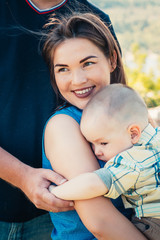 Happy family with baby son on nature background