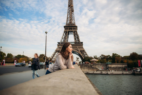 Beautiful young girl in front of eiffel tower. Girl is smiling and rejoising. autumn photo