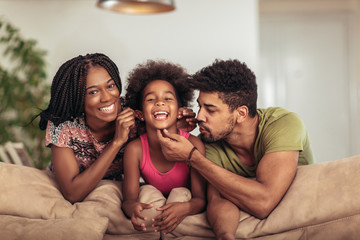 Obraz premium Happy family posing on the couch together at home in the living room