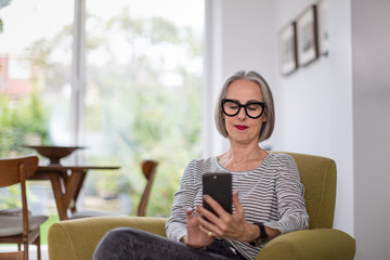 Mature adult female using a smartphone at home