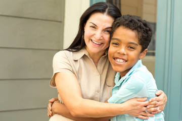 Happy Hispnaic mother smiling and hugging her son.