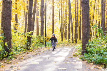 Fototapeta premium Fall, childhood, people concept - little happy girl walking in autumn park