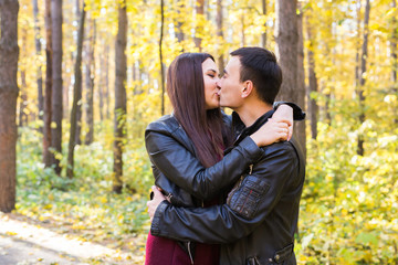 Relations, nature and love concept - Handsome man kissing beautiful woman in autumn nature