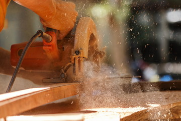 The carpenter works with the electric polisher on the wood.