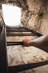 Rusty metal ladder with male hand holding it