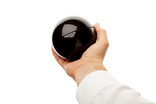 Male hand holds black glossy plastic sphere