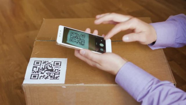 Scanning QR code with smart phone. The man reads the bar code using the application on the smartphone.