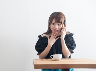 スマホ・女性・カフェテーブル