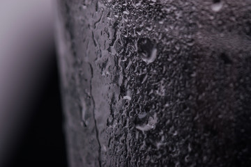Glass on a dark blurry background with drops of water