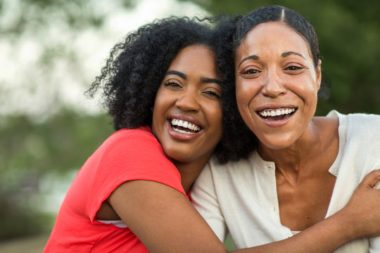 African American mother hugging her adult daughter.
