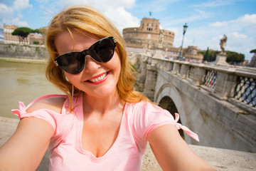 Woman taking selfy in front of Castel Sant’Angelo in Rome, Italy