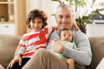 Obraz premium family, fatherhood and people concept - happy father with preteen and baby son at home
