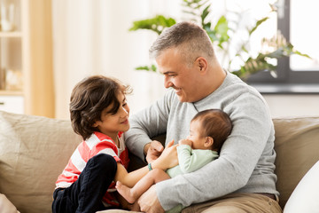 Obraz premium family, fatherhood and people concept - happy father with preteen and baby son at home