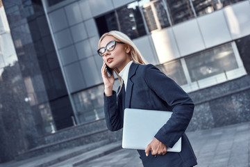 Successful business woman working at laptop in City