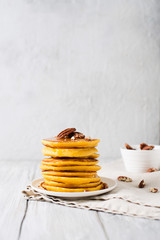 Stack of pancakes with pecan and syrup in nordic style
