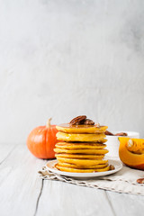Stack of pancakes with pecan and syrup in nordic style