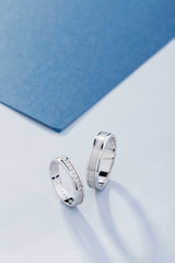 Pair of white gold wedding rings with diamonds in womens ring and matte surface in mens ring