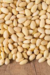 peeled almonds on wooden surface