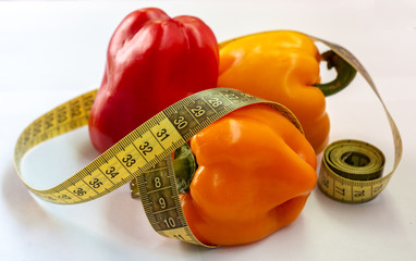 measuring tape and pepper on a white background. Fitness - Powered by Adobe