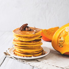 Stack of pancakes with pecan and syrup in nordic style