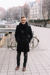 Street portrait of mature man wearing black coat