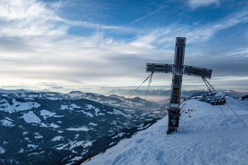 Gipfelkreuz im Winter mit Ausblick auf die Berglandschaft