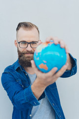 Confident young man holding a geographic globe