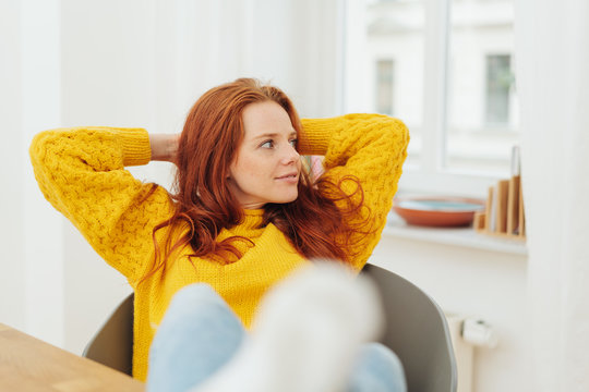 frau verschr&auml;nkt die arme hinter den kopf und schaut entspannt zur seite