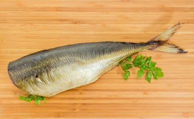Smoked Atlantic horse mackerel without head on bamboo cutting board