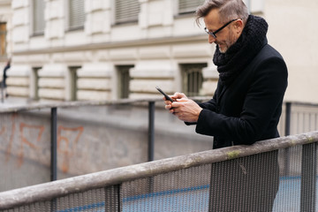 Businessman standing using a mobile in town