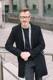 Street portrait of mature man wearing black coat