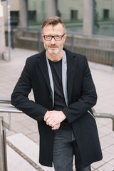 Street portrait of mature man wearing black coat